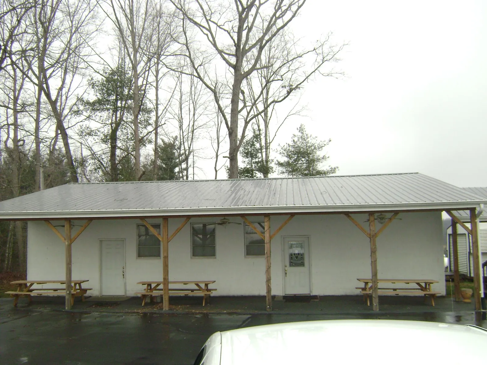 Gray metal roof over a block building with a timber post porch in Raleigh